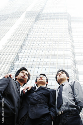 Photo: Three businessmen standing in front of the building. Three businessmen standing in front of the building.