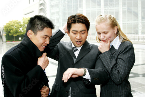 Photo: A group of business people looking at the time. A group of business people looking at the time.