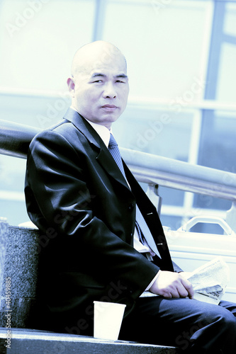 Photo: A bald man sitting on the bench. A bald man sitting on the bench.