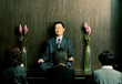 Three women praying in front of a meditating man. 