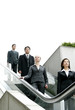 Photo: A group of business people coming down from an escalator. A group of business people coming down from an escalator.