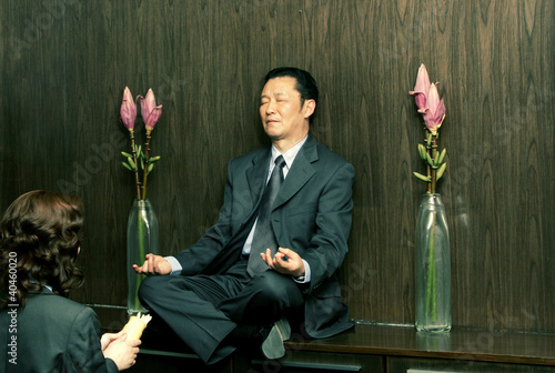 Foto: A woman praying in front of a meditating man. A woman praying in front of a meditating man.
