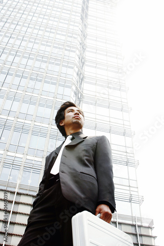 Foto: Man in business suit carrying a briefcase. Man in business suit carrying a briefcase.