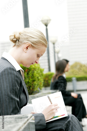 Photo: A woman writing something on her organizer. A woman writing something on her organizer.
