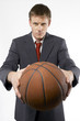 Man in business suit holding a basketball. 
