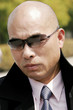 Foto: Bald man in business suit looking smart with sunglass. Bald man in business suit looking smart with sunglass.