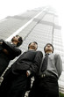 Foto: Low angle view of three businessmen standing in front of the building. Low angle view of three businessmen standing in front of the building.