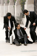 Two men helping his friend up after he slipped.