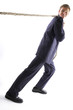 Man in business suit pulling a rope with all his might. 