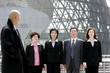 A bald man watching his employees standing at attention. 