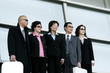 Business men and women in sunglasses standing in a row. 