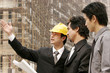 Architect discussing a building plan with his client at a construction site. 