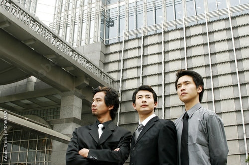 Photo: Three businessmen standing in front of the building. Three businessmen standing in front of the building.