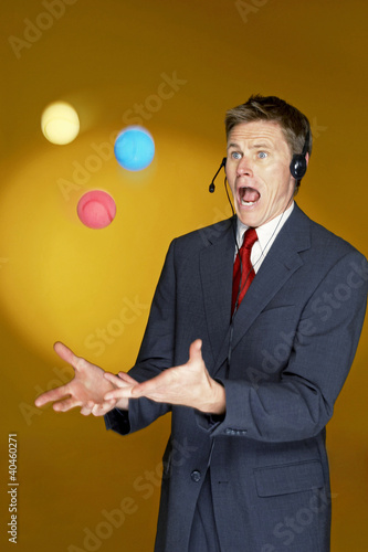 Photo: Man trying to juggle with three balls. Man trying to juggle with three balls.