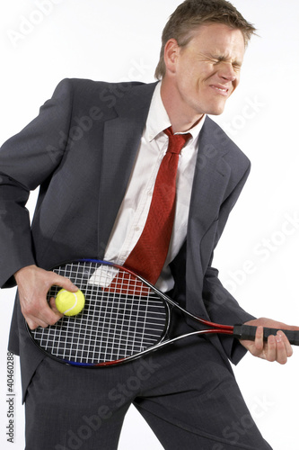 Photo: Businessman holding a tennis racquet and ball like playing a guitar. Businessman holding a tennis racquet and ball like playing a guitar.