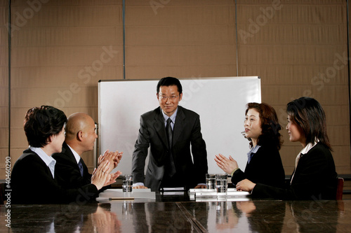 Photo: Business man and women clapping their hands after a good presentation. Business man and women clapping their hands after a good presentation.