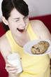 Woman holding cookies and a glass of milk.
