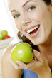 Woman holding a green apple.