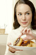 Woman holding a plate of doughnuts.