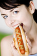 Woman eating hotdog.