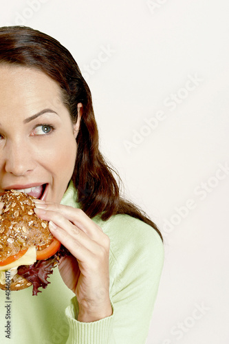 Photo: Woman eating burger. Woman eating burger.