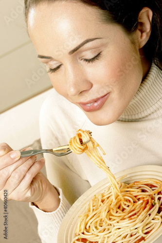 Photo: Woman enjoying a bowl of spaghetti. Woman enjoying a bowl of spaghetti.