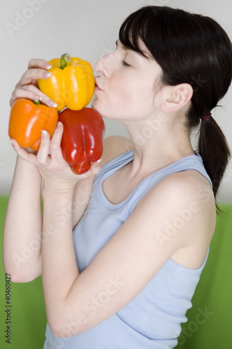 Photo: Woman holding capsicums. Woman holding capsicums.