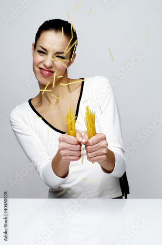 Photo: Woman breaking dry spaghetti. Woman breaking dry spaghetti.
