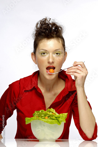 Foto: Woman eating a bowl of salad. Woman eating a bowl of salad.