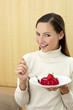 Woman holding a plate of strawberry jelly.