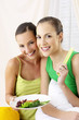 Women holding vegetables.