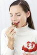 Woman eating strawberry.