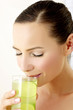 Woman drinking a glass of green apple juice.