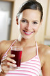 Woman drinking a glass of blackcurrant juice.