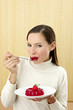 Photo: Woman eating strawberry jelly. Woman eating strawberry jelly.