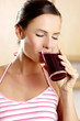 Photo: Woman drinking a glass of blackcurrant juice. Woman drinking a glass of blackcurrant juice.