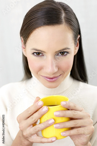 Photo: Woman holding a cup of coffee. Woman holding a cup of coffee.