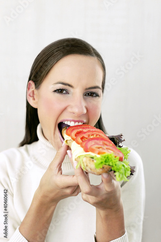 Photo: Woman eating a specially made croissant. Woman eating a specially made croissant.