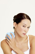 Foto: Woman holding a body sponge. Woman holding a body sponge.