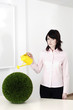 Businesswoman watering plants.
