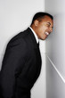 Businessman knocking his head against the wall.