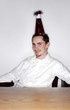 Photo: Businessman with party hat smiling at the camera. Businessman with party hat smiling at the camera.