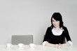 Businesswoman sitting beside three arranged cups.