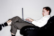 Photo: Businessman sitting on the couch using laptop. Businessman sitting on the couch using laptop.
