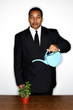 Foto: Businessman watering plants. Businessman watering plants.