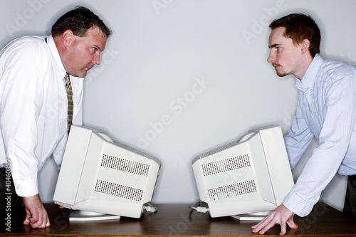 Photo: Two businessmen looking at each other angrily. Two businessmen looking at each other angrily.