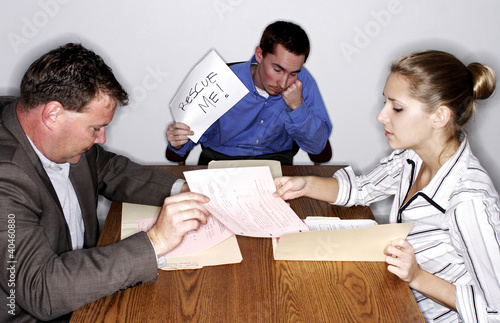 Photo: An uninterested man holding a 'Rescue Me' sign during a transaction. An uninterested man holding a 'Rescue Me' sign during a transaction.