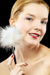 Photo: Woman tickling her face with white fur. Woman tickling her face with white fur.