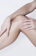 Foto: Woman touching her leg. Woman touching her leg.