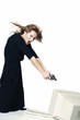 Businesswoman pointing her pistol at a computer monitor.